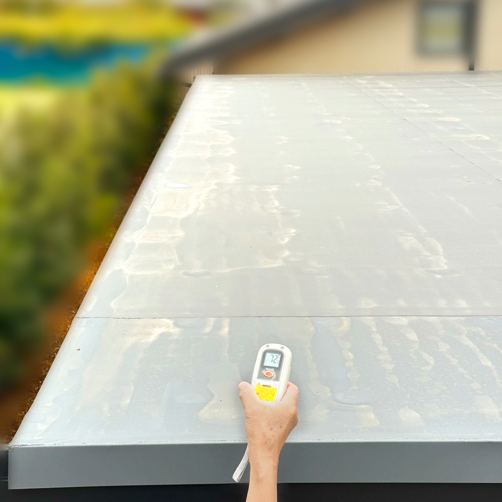 屋外の屋根表面温度を計測している様子。太陽光にさらされた屋根表面が72℃に達していることを示す温度計の数値